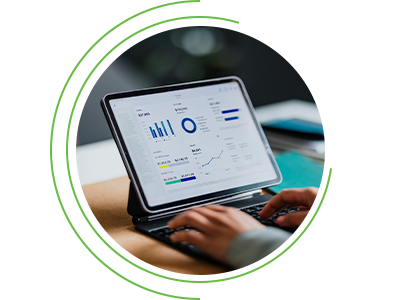 Person typing on a keyboard connected to a tablet displaying a dashboard with charts and performance metrics, framed within a circular graphic.