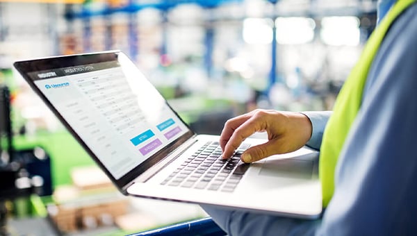 a professional in a safety vest looking at a computer