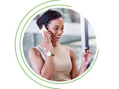 Smiling woman talking on a smartphone while holding a credit card, framed within a circular graphic.